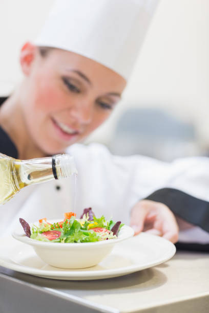 istock Chef pouring olive oil over salad 827262154