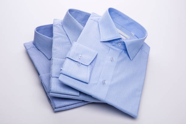 istock Three blue men's shirts folded in a pack on a white background. 827263642