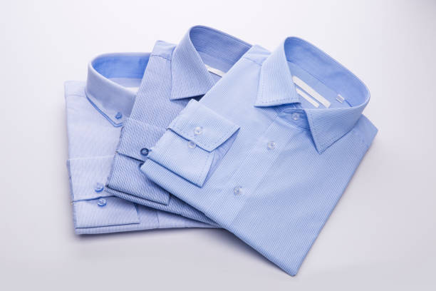 istock Three blue men's shirts folded in a pack on a white background. 827263702