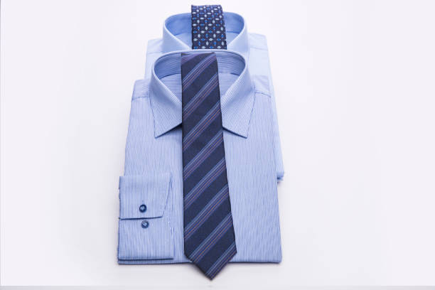 istock Three blue men's shirts folded in a pack and tie on a white background. 827265994