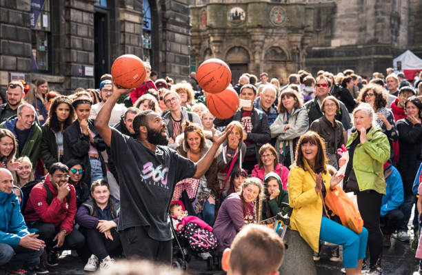 Edinburgh, Scotland, UK - A street performer delighting crowds with basketball tricks on the Royal Mile, during the annual Edinburgh Festival Fringe.