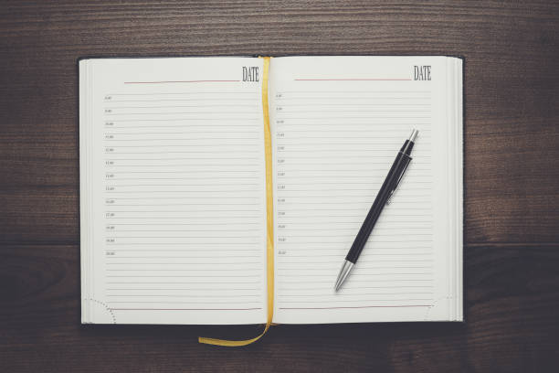 opened notebook and pen on wooden table
