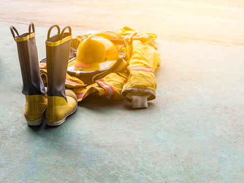 amarillo uniforme ignífugo de los bomberos. En el piso. Luz de la llamarada. photo