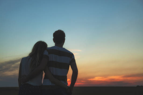 istock Young couple enjoying outdoors in the field. 827277476