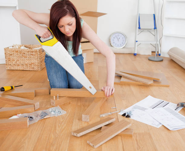 istock Good looking redhaired female using a saw for diy at home 827279790
