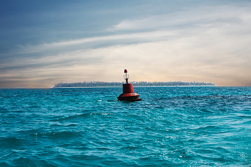 A red buoy floats in the middle to mark the direction and depth for boats