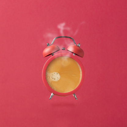 Alarm clock as coffee cup over pink background. Creative modern still life photography concept