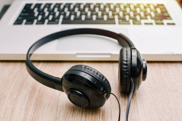 istock Headphones and laptop on table wood 827284956