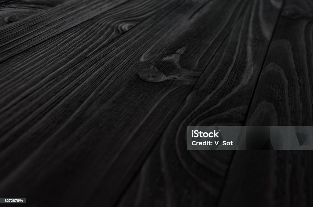 Black Wood Texture Black Wood Texture close-up. Shield from diagonally directed boards with wavy pattern of fibers. Wood - Material Stock Photo