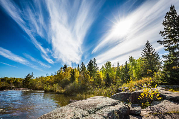 Incredible cirrus clouds  and huge flat stones in Old Pinawa Dam Park. Indian summer in Manitoba, Canada. The concept of ecological tourism stock photo