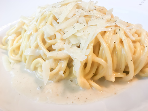 Spaghetti Alfredo, white sauce based on cream milk, butter, garlic, cheese, white pepper, and nutmeg topped with parmensan