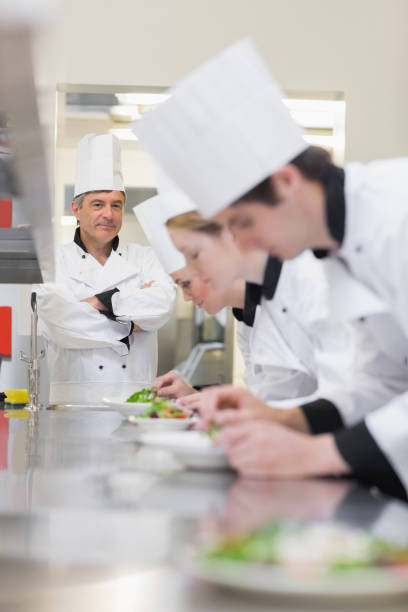 istock Culinary class making salads as teacher is supervising 827292440