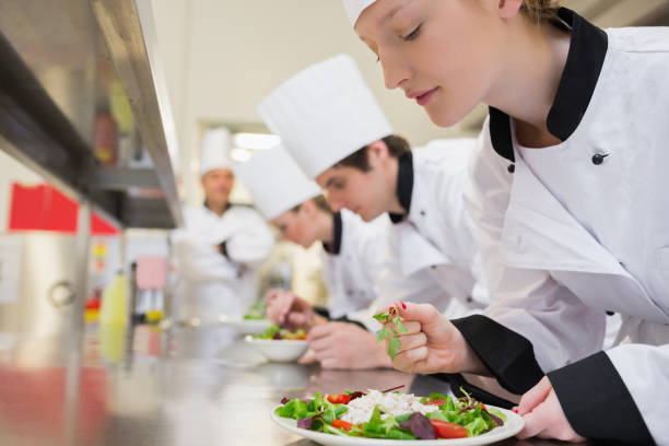 istock Chef finishing her salad in culinary class 827292740