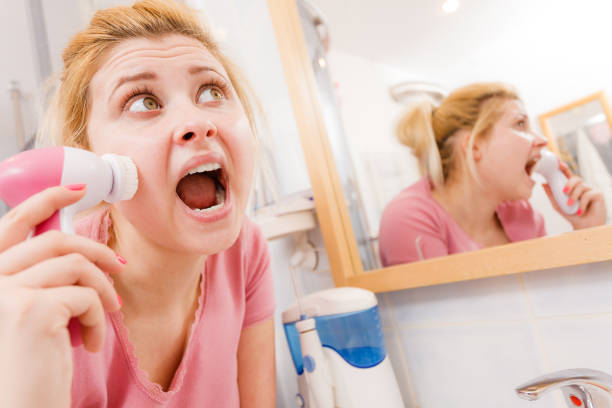istock Shocked woman using facial cleansing brush 827295876