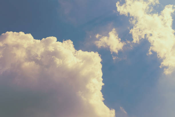 istock Large clouds toned in pink on a blue sky, lit by the sun. Abstract sky 827302624