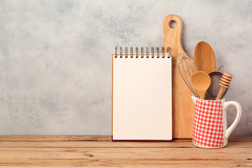 En blanco portátil y utensilios de cocina en la mesa de madera sobre fondo rústico con espacio de copia photo