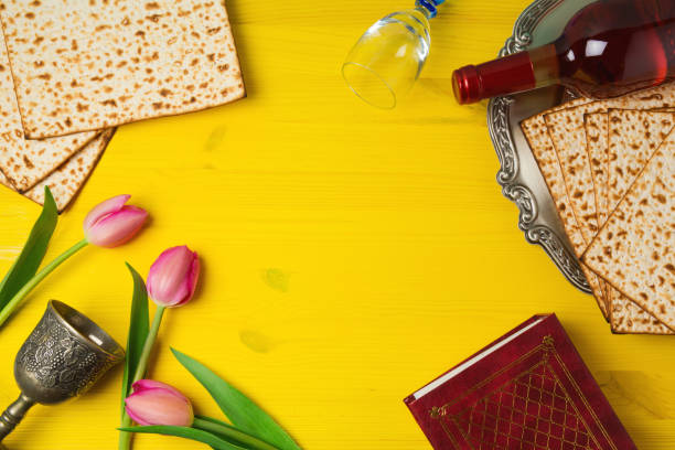 obchody paschy pesah z matzoh, kwiaty tulipanów i butelkę wina na żółtym drewnianym tle. widok z góry - passover matzo wine wine bottle zdjęcia i obrazy z banku zdjęć