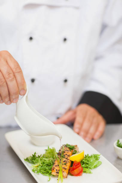 istock Chef pouring sauce on salmon 827333706