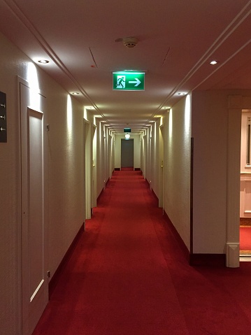 Hotel hallway with bright light and window glass at the end
