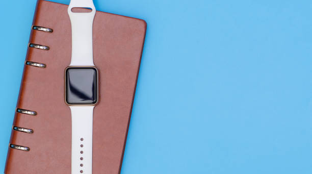 istock Smart watch on notebook for organize concept with blue copy space 827344230