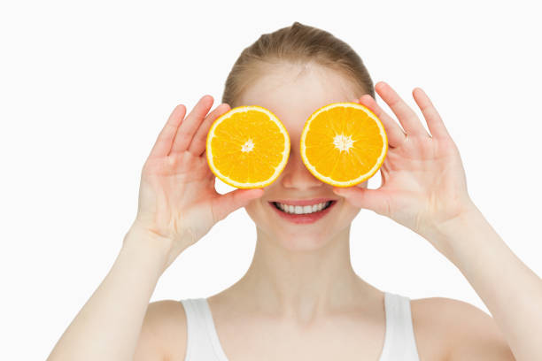 istock Smiling woman placing oranges on her eyes 827349354