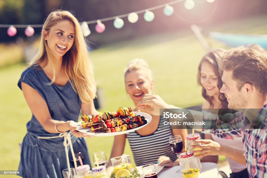 Friends having barbecue party in backyard Picture showing group of friends having barbecue party in backyard Barbecue - Meal Stock Photo