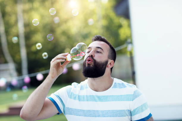 istock Young man blowing bubbles outdoors 827358978