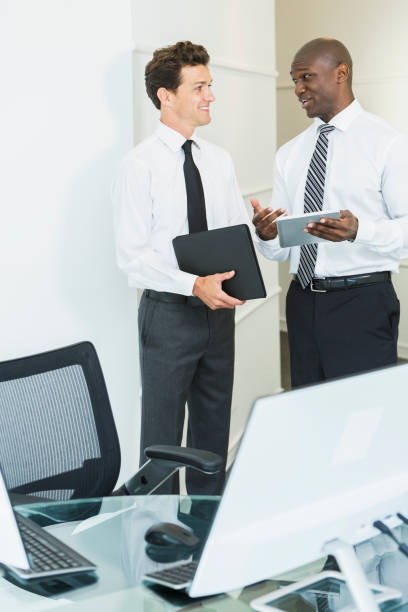 istock Two businessmen in office talking over digital tablet 827359456