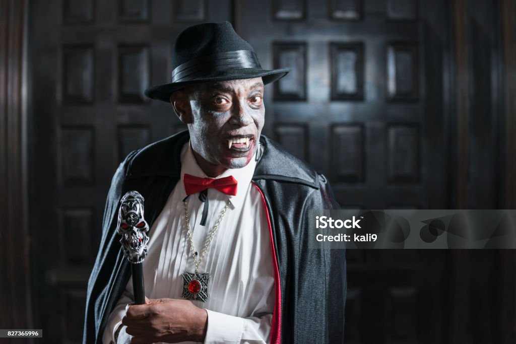 Vampire at adult halloween party A senior African-American man in his 60s wearing a vampire costume at an adult halloween party. Halloween Stock Photo