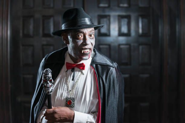 Vampire at adult halloween party A senior African-American man in his 60s wearing a vampire costume at an adult halloween party. face paint halloween adult men stock pictures, royalty-free photos & images