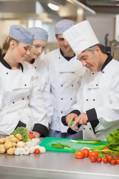 Photo of Chef teaching trainees how to cut vegetables
