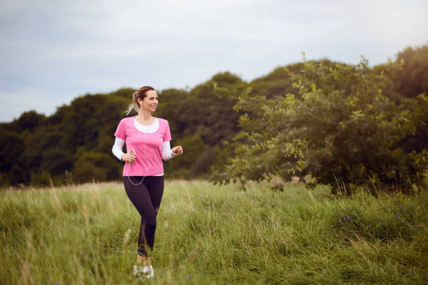 istock Fit middle-aged woman walking through a field 827369044