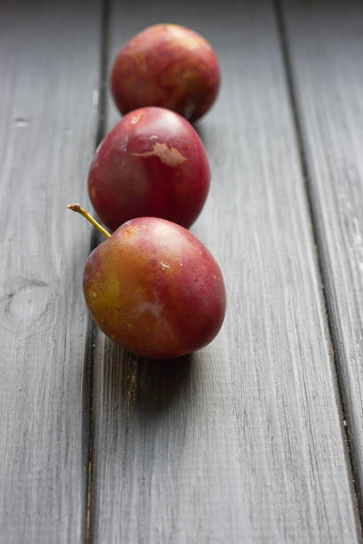 istock fresh plums on wooden table 827380844