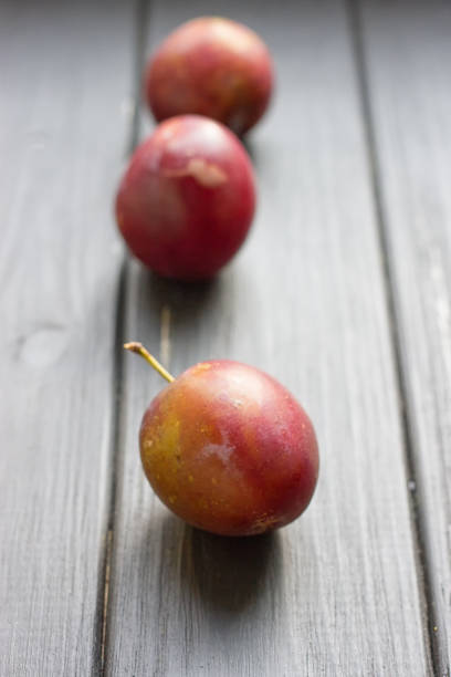 istock fresh plums on wooden table 827382796