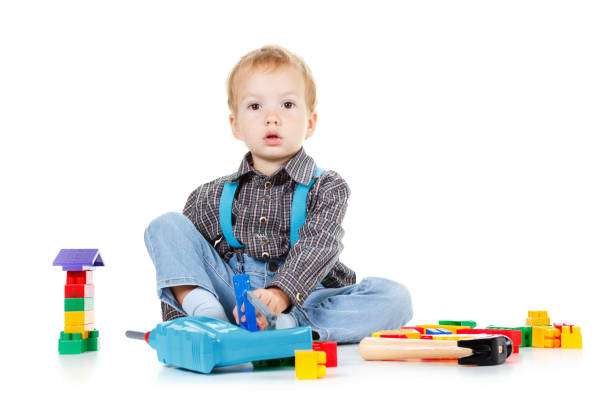 istock Little boy plays in the builder with tools. isolated over white. 827389970