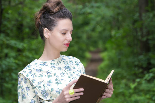 istock Girl in the woods with a book 827390490