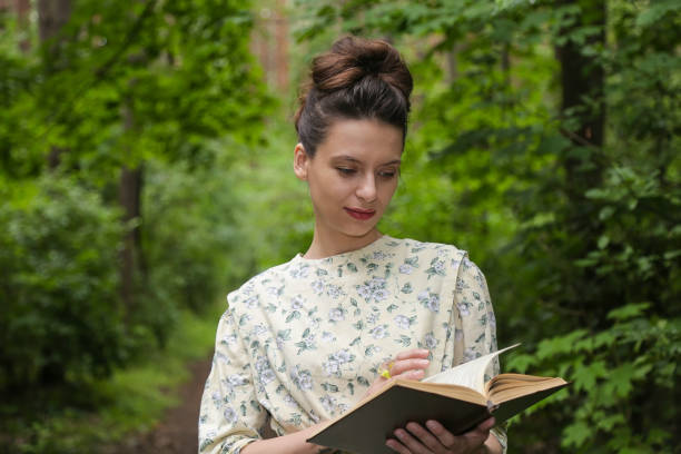 istock Girl in the woods with a book 827390554