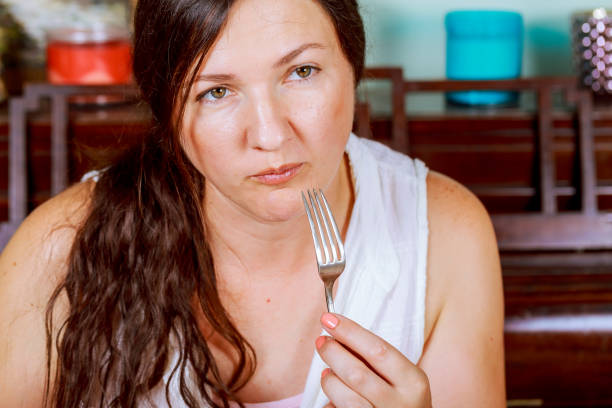 istock beautiful young woman eating in restaurant 827390618