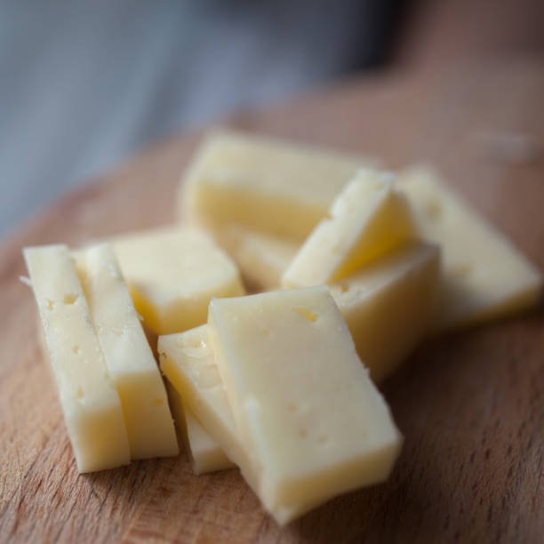 istock Sliced cheese lying on a wooden platter 827394776