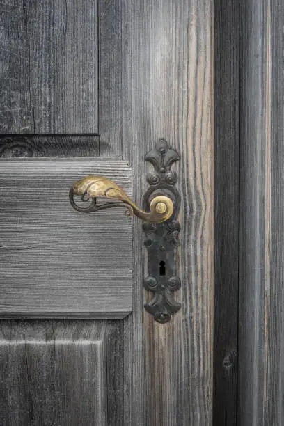The old wooden door with doorhandle and keyhole.