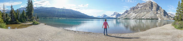 istock Young man contemplating nature at mountain lake 827400294