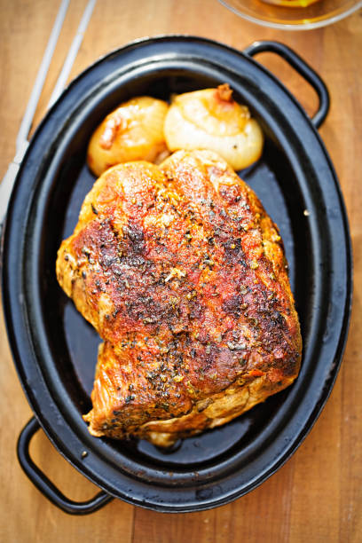 istock Roasted pork shoulder with onions in gravy 827400476