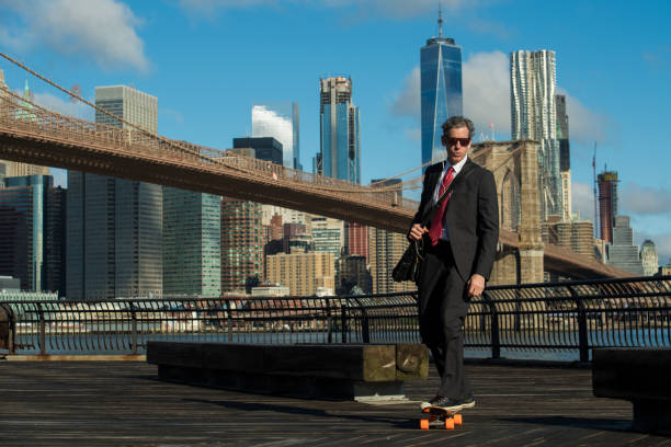 homme d’affaires, planche à roulettes à new york city - east river audio photos et images de collection