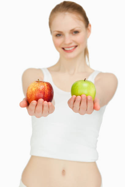 istock Cheerful woman presenting two apples 827407416