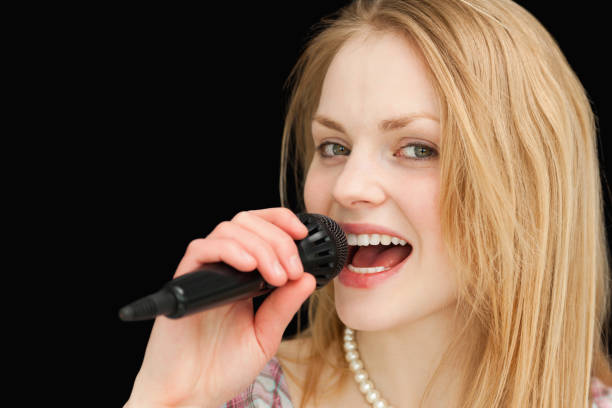 Young blonde with headsets and microphone against white background. Horizontally framed shot.