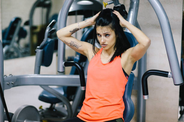 istock Young woman doing stength exercise in the gym 827416818