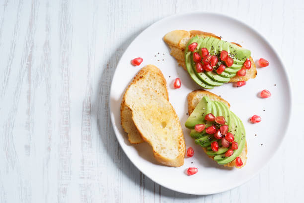 istock sliced avocado on toast bread with pomegranate seeds. 827429980