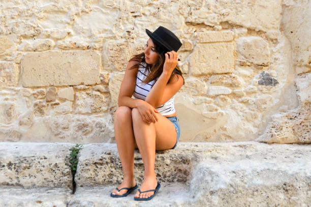 istock Attractive young woman sitting on stone steps 827432612