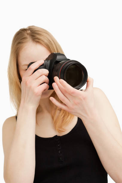 istock Young woman aiming with a camera 827442234