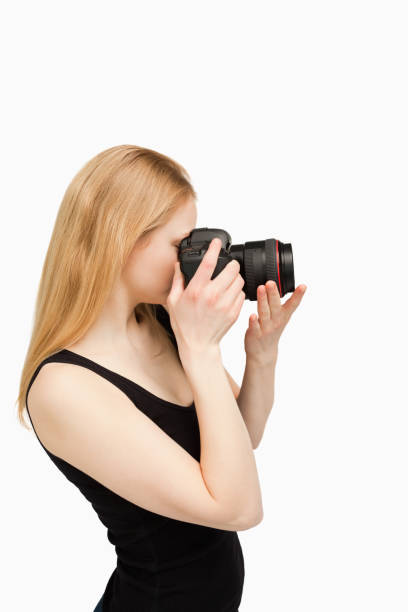 istock Blondehaired woman aiming with a camera 827442266